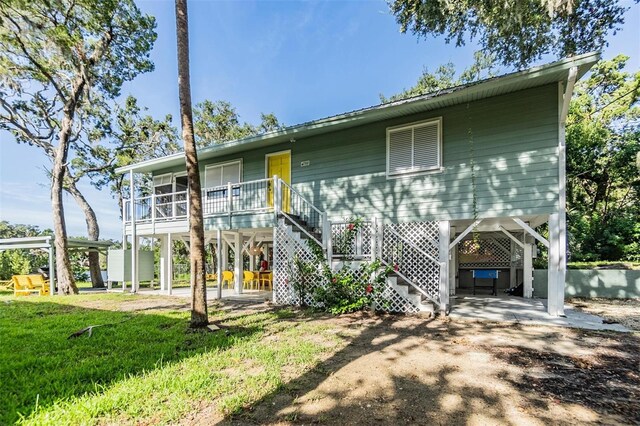 back of property with a lawn and a carport