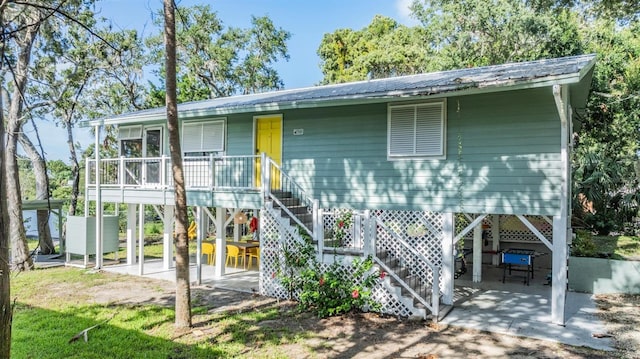 14640 W Black Creek Dr, Crystal River, FL 34429 - coastal home featuring a patio area, metal roof, and stairway