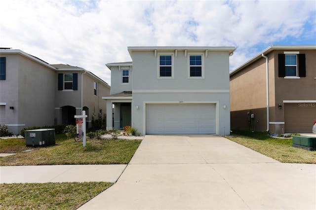 traditional-style home featuring driveway, central AC unit, an attached garage, a front lawn, and stucco siding