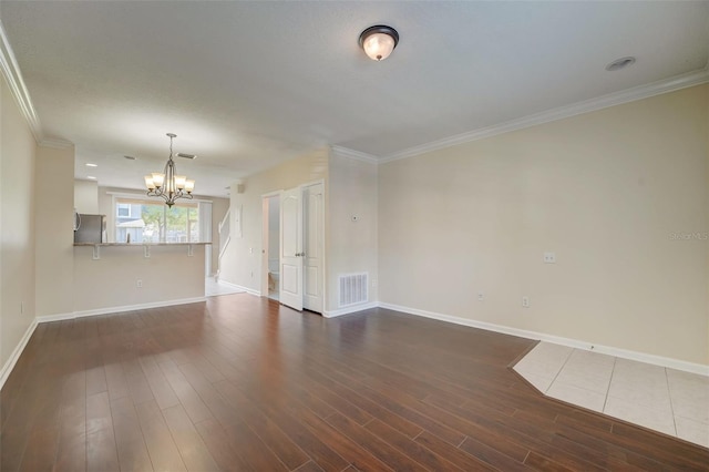 unfurnished room featuring crown molding, dark tile floors, and a chandelier