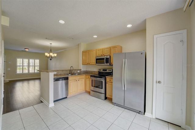 kitchen featuring light tile flooring, kitchen peninsula, a notable chandelier, and appliances with stainless steel finishes