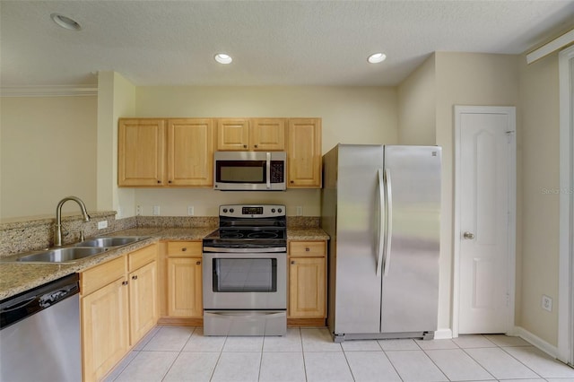 kitchen with light brown cabinetry, light tile floors, appliances with stainless steel finishes, and sink