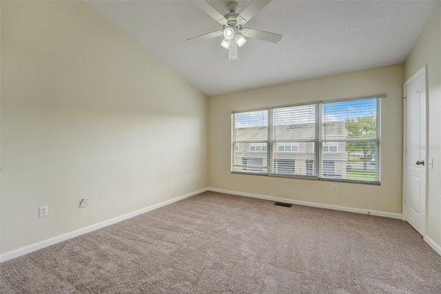 carpeted spare room featuring lofted ceiling and ceiling fan