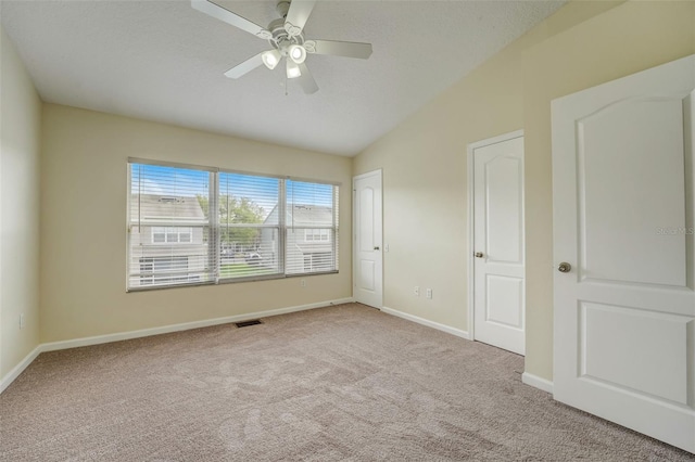 carpeted spare room with lofted ceiling and ceiling fan