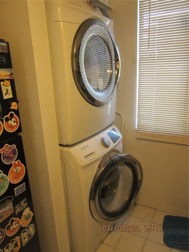 clothes washing area with tile flooring and stacked washing maching and dryer