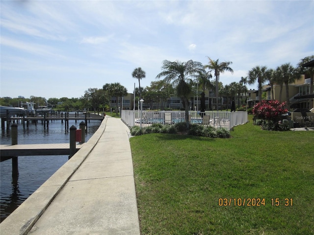 dock area featuring a lawn and a water view