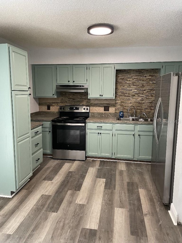 kitchen with dark wood-type flooring, stainless steel appliances, and green cabinetry