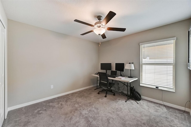 carpeted home office featuring ceiling fan