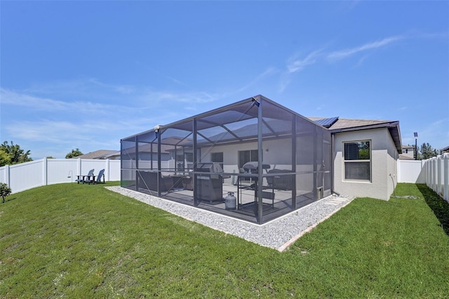 back of property with solar panels, a yard, and a patio area