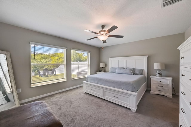 bedroom with a textured ceiling, light colored carpet, and ceiling fan