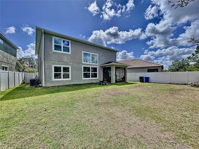 rear view of house with a yard and central AC unit