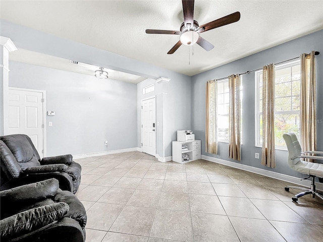 tiled living room featuring ceiling fan and a textured ceiling