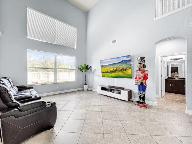 living room with a high ceiling and light tile floors