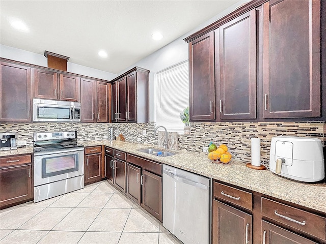 kitchen featuring light stone countertops, tasteful backsplash, and stainless steel appliances