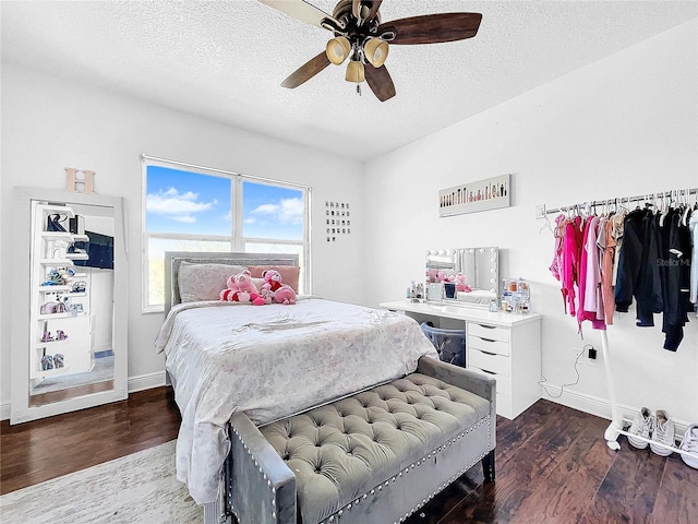 bedroom with ceiling fan, a textured ceiling, and dark hardwood / wood-style flooring