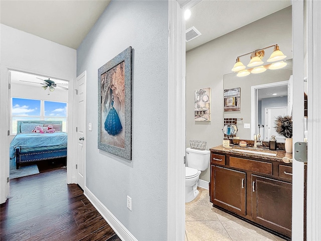 bathroom featuring hardwood / wood-style flooring, ceiling fan, vanity, and toilet