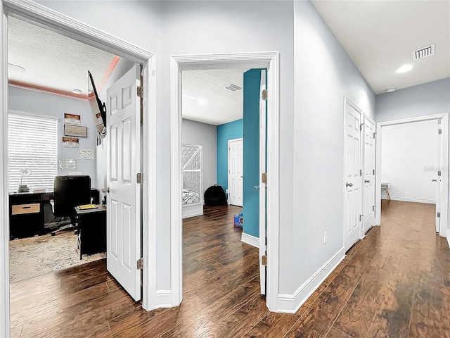 hallway featuring dark hardwood / wood-style floors and a textured ceiling