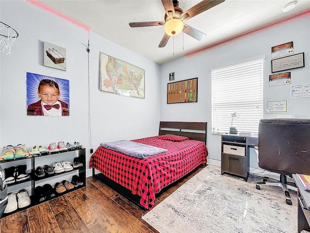 bedroom featuring a textured ceiling, dark hardwood / wood-style floors, and ceiling fan