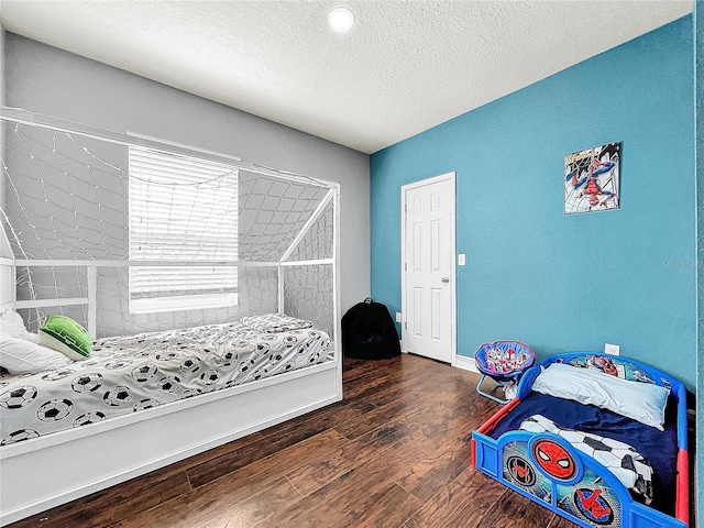 bedroom with dark wood-type flooring and a textured ceiling