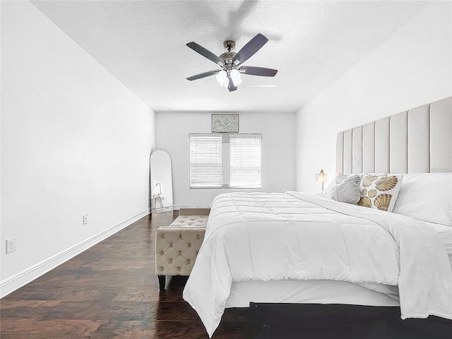 bedroom featuring a textured ceiling, ceiling fan, and dark wood-type flooring