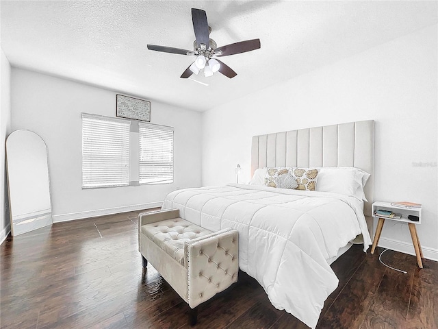 bedroom featuring a textured ceiling, ceiling fan, and dark wood-type flooring