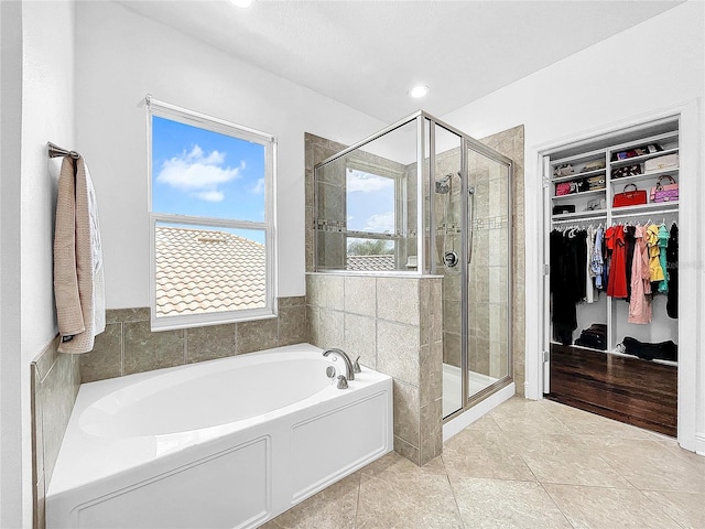 bathroom with shower with separate bathtub and tile floors