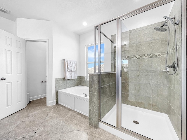 bathroom featuring a textured ceiling, shower with separate bathtub, and tile flooring