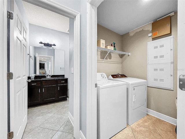 clothes washing area with light tile floors and washer and clothes dryer