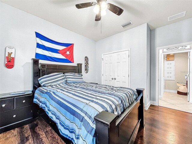 bedroom with a closet, ceiling fan, and dark hardwood / wood-style flooring