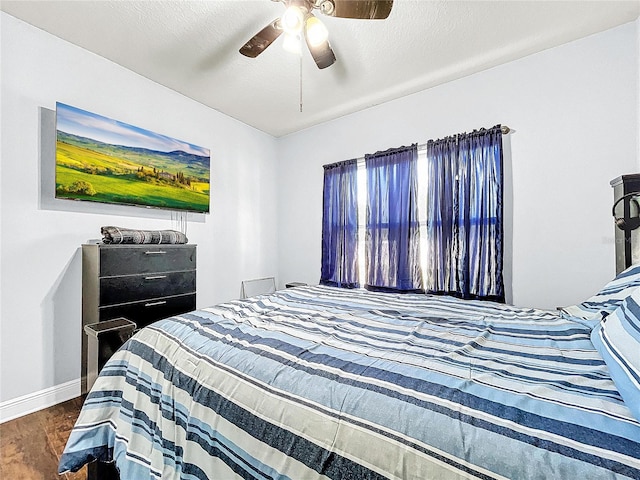 bedroom with ceiling fan and dark hardwood / wood-style flooring