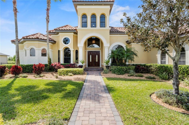 mediterranean / spanish home with french doors and a front lawn