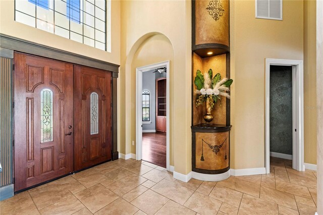 entryway featuring light tile floors and a high ceiling