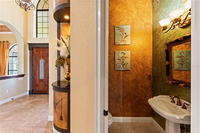 bathroom with toilet, tile floors, and sink