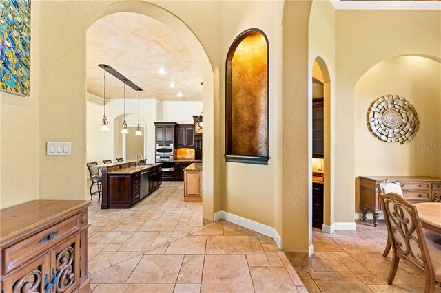 hall with sink and light tile flooring