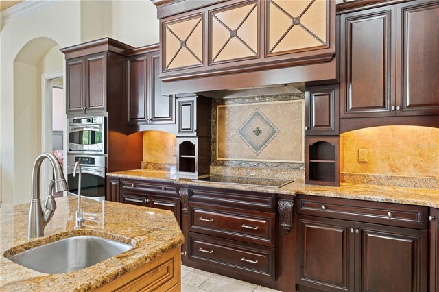 kitchen featuring backsplash, black electric cooktop, sink, premium range hood, and light stone counters