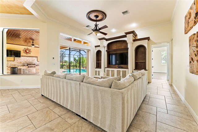 tiled living room with crown molding, ceiling fan, and built in shelves