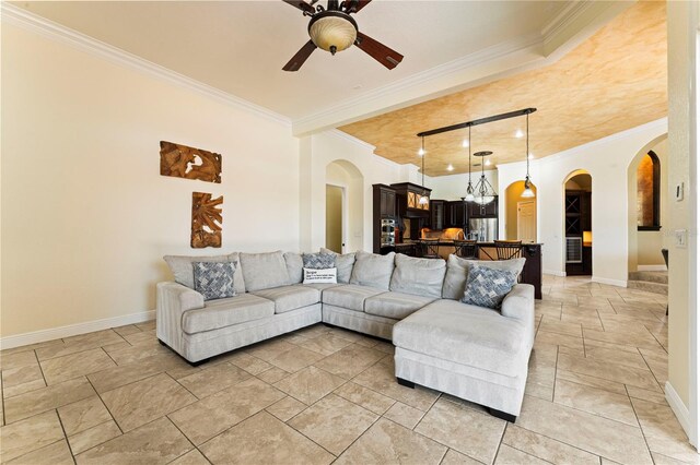 tiled living room with ornamental molding and ceiling fan with notable chandelier