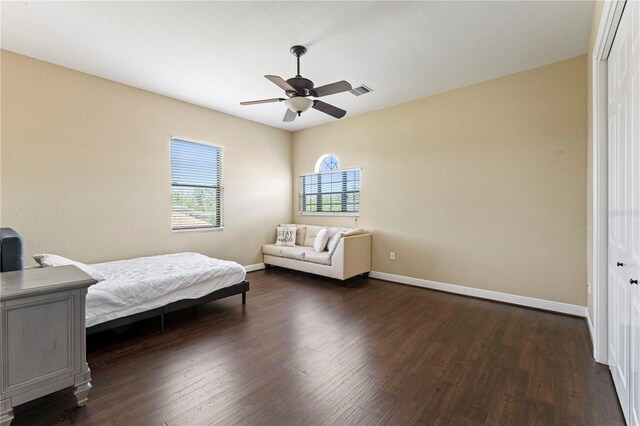 bedroom featuring dark hardwood / wood-style flooring, a closet, and ceiling fan