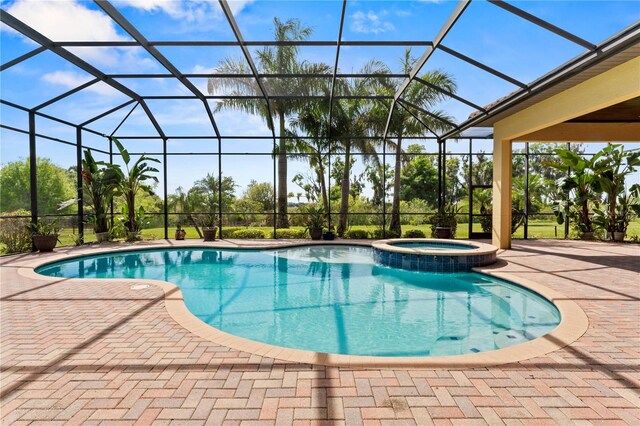 view of pool featuring an in ground hot tub, a lanai, and a patio