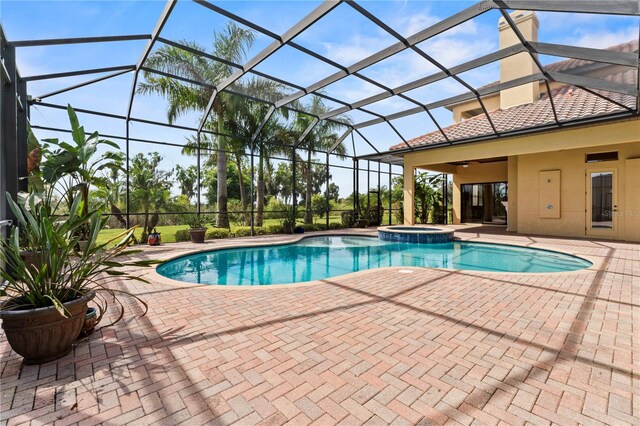 view of swimming pool featuring a patio, an in ground hot tub, ceiling fan, and glass enclosure