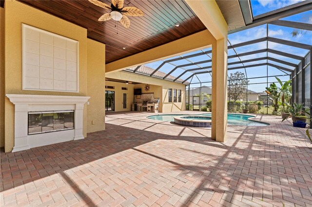 view of pool featuring a patio area, an in ground hot tub, ceiling fan, and a lanai