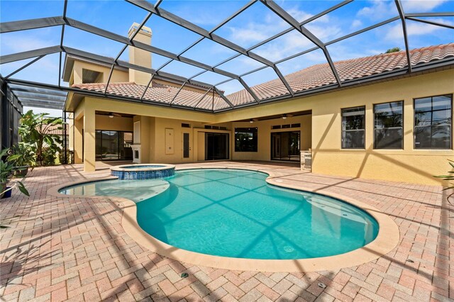 view of pool featuring a patio, an in ground hot tub, ceiling fan, and glass enclosure