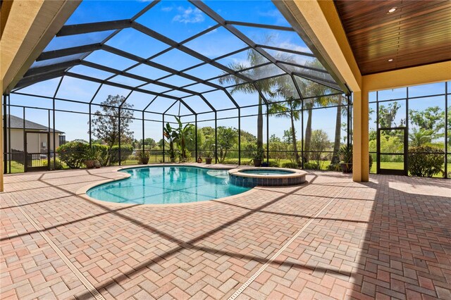 view of swimming pool with an in ground hot tub, a lanai, and a patio area