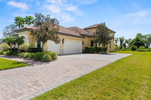 mediterranean / spanish house with a front yard and a garage