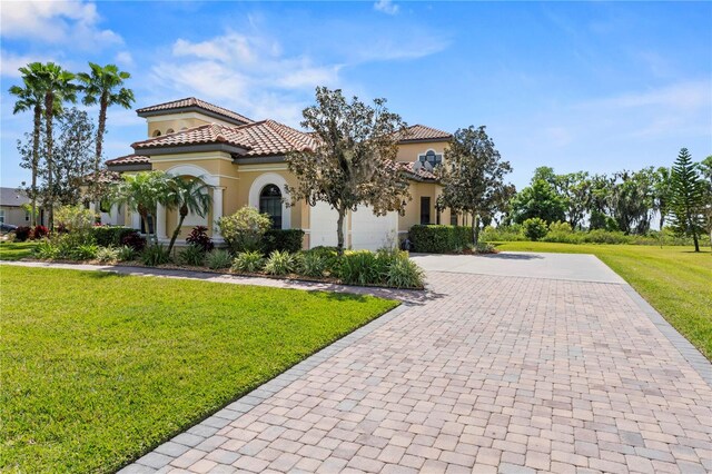 mediterranean / spanish house with a front yard and a garage