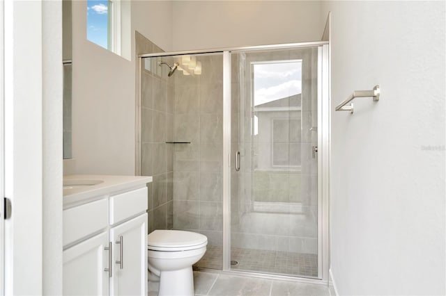 bathroom featuring tile patterned floors, vanity, an enclosed shower, and toilet