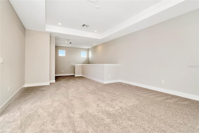 unfurnished room featuring light carpet and a tray ceiling