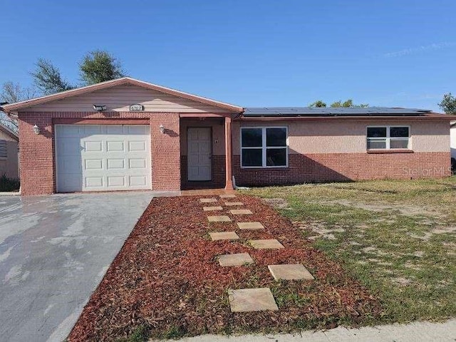 ranch-style home with solar panels and a garage