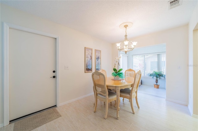 dining room with a chandelier and a textured ceiling