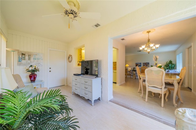 interior space with ceiling fan with notable chandelier